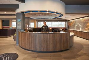 a man standing at a reception desk in a lobby at Tru By Hilton Jacksonville South Mandarin, Fl in Jacksonville