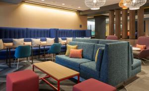 een wachtkamer met een bank en tafels en stoelen bij Tru By Hilton Jacksonville South Mandarin, Fl in Jacksonville