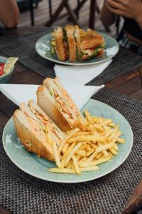 dos platos de sándwiches y papas fritas en una mesa en Hello Villas, en Carvoeiro