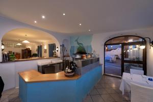 una cucina con bancone e una sala da pranzo di Hotel Villa Sirena a Ischia
