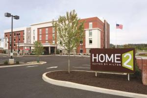 蔓越莓乡Home2Suites Pittsburgh Cranberry的建筑物前停车场的标志