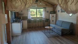 a living room with a couch and a table and a kitchen at La vallée des noyers in Beaulieu