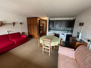 een woonkamer met een rode bank en een tafel bij Monolocale Alberti Rainalter in Madonna di Campiglio