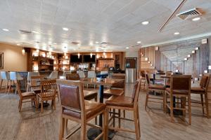 uma sala de jantar com mesas e cadeiras de madeira em DoubleTree by Hilton Phoenix- Tempe em Tempe