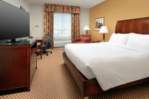 a hotel room with a bed and a flat screen tv at Hilton Garden Inn Odessa in Odessa