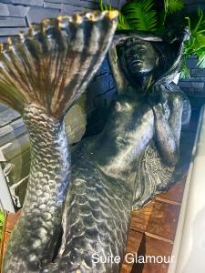 a bronze statue of a mermaid with a shell at Faranel in Berlaimont