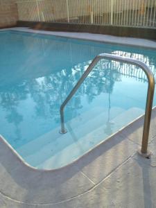 a swimming pool with a metal rail in the water at Riviera Motel in Anaheim