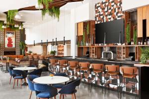 a restaurant with tables and chairs and a bar at Canopy By Hilton Tempe Downtown in Tempe