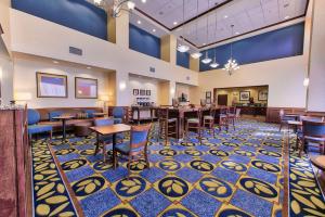 a rendering of a dining room with tables and chairs at Hampton Inn & Suites Ridgecrest in Ridgecrest
