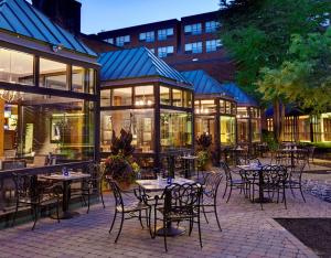 a patio with tables and chairs in front of a building at The Saratoga Hilton in Saratoga Springs