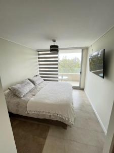 1 dormitorio con cama y ventana grande en Algarrobo Espectacular piso 10 vista bahía en Algarrobo