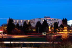 a large building with lights in front of a park at Embassy Suites by Hilton Portland Washington Square in Tigard