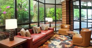 a lobby with a couch and chairs and windows at Embassy Suites by Hilton Portland Washington Square in Tigard