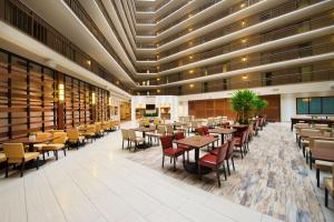 a restaurant with tables and chairs in a building at Embassy Suites by Hilton Portland Washington Square in Tigard