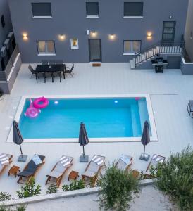 an overhead view of a pool with chairs and a table at Luxury Apartment Lorena - Private Heated Pool - in Jesenice