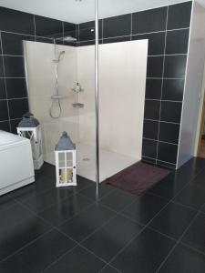 baño con ducha de azulejos negros en A la maison du Bonheur, en Lanty-sur-Aube