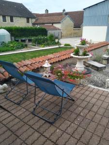un par de sillas y flores en un patio en A la maison du Bonheur, en Lanty-sur-Aube 3 fotos más