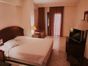 a hotel room with a bed and a television at Europa Beach Hotel in Galaxidi