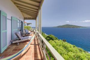 a balcony of a house with a view of the ocean at St Thomas Cliffside Villa with Pool and Hot Tub! in Lovenlund