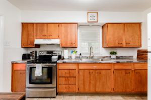 a kitchen with wooden cabinets and a stove top oven at Lovely Landing Pad near Lambert Airport 3 bed bath in Berkeley