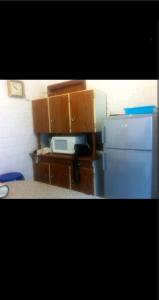 eine Küche mit einem blauen Kühlschrank und Holzschränken in der Unterkunft Casa dala, en aguiño in Ribeira