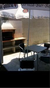 een tafel en stoelen met een tafel en een parasol bij Casa dala, en aguiño in Ribeira