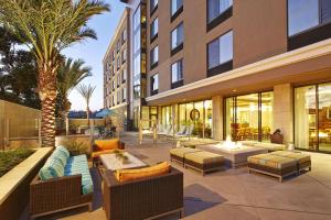 eine Terrasse mit Sofas und Stühlen sowie ein Gebäude in der Unterkunft Hampton Inn San Diego Mission Valley in San Diego