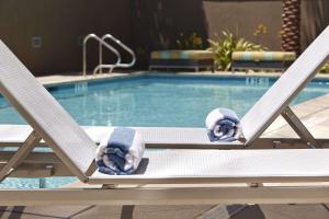 a couple of chairs sitting next to a swimming pool at Hampton Inn San Diego Mission Valley in San Diego