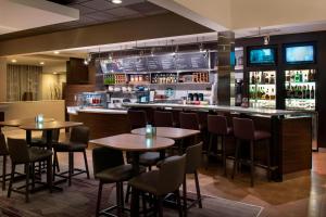 a bar with tables and chairs in a restaurant at Courtyard by Marriott Chicago Waukegan / Gurnee in Waukegan