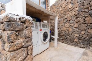Los PocillosRelaxing upper floor Apartment- exclusive complex.的石墙旁的洗衣机