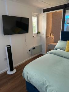 a bedroom with a bed with a flat screen tv on the wall at Nice and Cosy Studio in Bristol