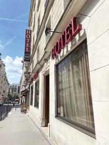 a store with a sign on the side of a building at Hôtel Média in Paris