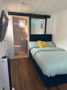 um quarto com uma cama e uma casa de banho com um lavatório em Nice and Cosy Studio em Bristol