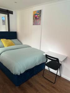 a bedroom with a bed with a desk and a chair at Nice and Cosy Studio in Bristol
