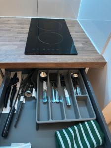 a drawer in a cabinet filled with cooking utensils at Nice and Cosy Studio in Bristol