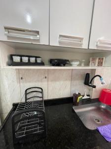 uma cozinha com um lavatório e uma cadeira em Apartamento Cabo Frio - 2 quartos em Cabo Frio