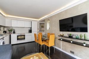 a kitchen and living room with a table and chairs at Elegant 3 bedrooms apartment near Hyde Park & Oxford St in London