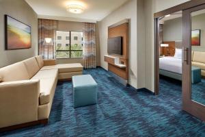 um quarto de hotel com um sofá e uma cama e uma televisão em Homewood Suites by Hilton San Diego Hotel Circle/SeaWorld Area em San Diego