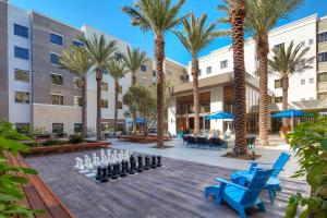 un patio con palmeras y una partida de ajedrez en Homewood Suites by Hilton San Diego Hotel Circle/SeaWorld Area, en San Diego