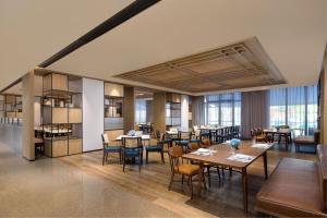 a dining room with tables and chairs and windows at Four Points by Sheraton Qiandao Lake in Thousand Island Lake