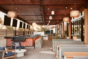 un restaurante con bar, sillas y mesas en Senna House Hotel Scottsdale, Curio Collection By Hilton, en Scottsdale