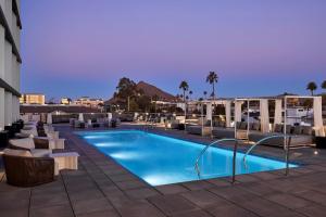 a swimming pool with lounge chairs and a resort at Senna House Hotel Scottsdale, Curio Collection By Hilton in Scottsdale
