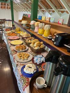 a buffet line with many different types of food at Pousada Ana Doce in São Sebastião