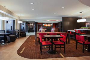 a restaurant with red chairs and tables and a bar at Courtyard by Marriott Corpus Christi in Corpus Christi