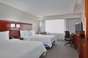 a hotel room with two beds and a television at Courtyard by Marriott Corpus Christi in Corpus Christi