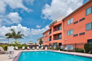 a hotel with a swimming pool in front of a building at Courtyard by Marriott Corpus Christi in Corpus Christi