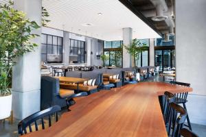 a dining room with wooden tables and chairs at Tapestry By Hilton The Fort Sutter Hotel Sacramento, Ca in Sacramento