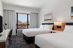 ein Hotelzimmer mit 2 Betten und einem TV in der Unterkunft Tapestry By Hilton The Fort Sutter Hotel Sacramento, Ca in Sacramento