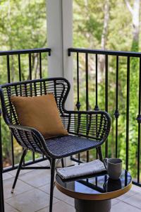 een stoel op een veranda met een kopje op een tafel bij The Inn at Saratoga, Tapestry Collection by Hilton in Saratoga