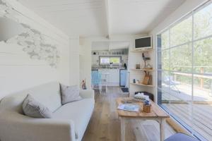 a living room with a white couch and a table at lodge avec vue sur la rivière in Lannion